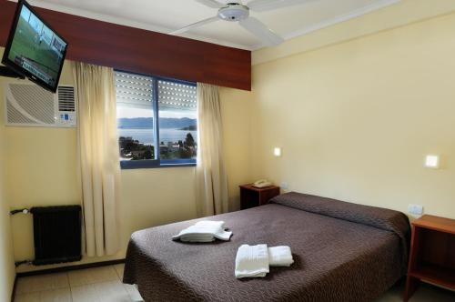 - une chambre avec un lit et 2 serviettes dans l'établissement Hotel Temu, à Villa Carlos Paz