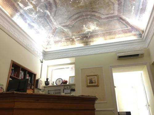 a living room with a ceiling withpaintedrosis at Hotel Positano in Rome