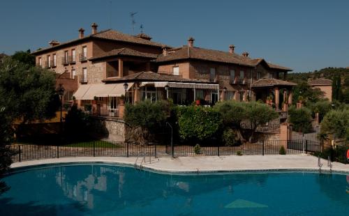 a large house with a swimming pool in front of a building at Abacería in Toledo