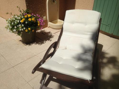 a white chair sitting on a patio with flowers at Le Relais des Malettes Chambres d'hôtes B&B in Francheville