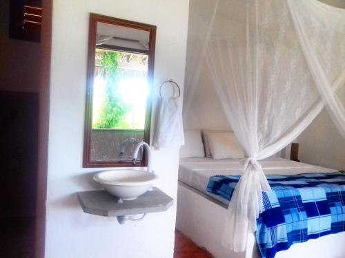 a bathroom with a bed and a sink and a window at Eco Kite Dunas in Prea