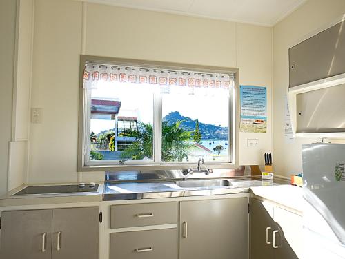 a kitchen with a sink and a window at Tairua Shores Motel in Tairua