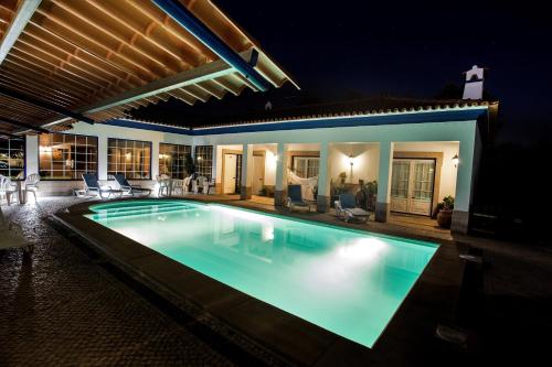 una piscina en un patio trasero por la noche en A Palhota, en Alpalhão