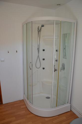 a shower with a glass door in a bathroom at la ferme fleurie in Echinghen