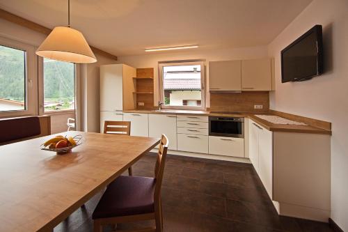 a kitchen with a table with a bowl of fruit on it at Haus St. Christoph in Mayrhofen