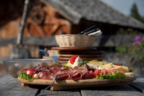 un piatto di cibo su un tavolo di legno con un panino di Reiterhof Edelweiss a San Genesio Atesino