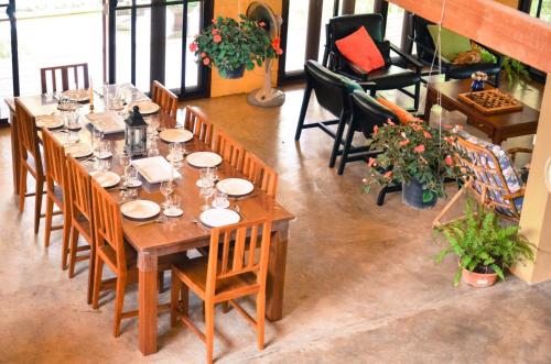 a long wooden table with chairs and wine glasses at Jardin De Mangue Pakchong in Pak Chong