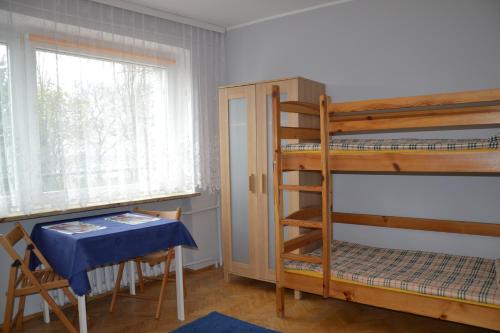 a room with two bunk beds and a table and a window at Bursztynowa Wyspa in Gdańsk