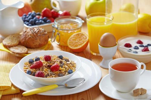a breakfast table with a bowl of cereal and fruit at Alpenhotel Stefanie in Mayrhofen