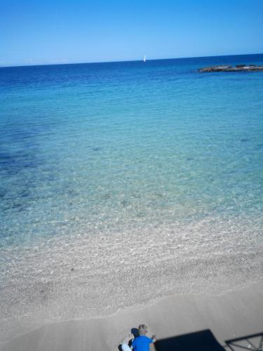 a person sitting on the beach looking at the ocean at Appartamento Antonacci in Monopoli