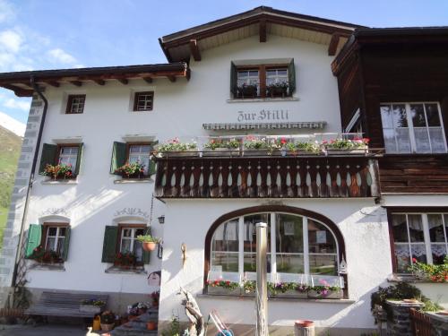 a white building with a sign on it at Pension Hof zur Stilli in Davos