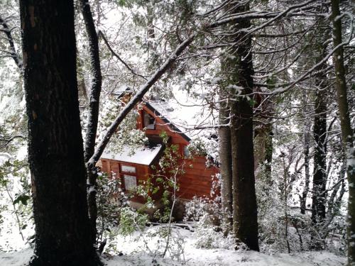 a cabin in the woods covered in snow at Calen-Hue in San Carlos de Bariloche