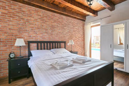 a large bed in a room with a brick wall at Istrian Villa Melany in Vodnjan