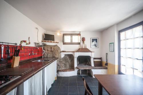 a kitchen with a fireplace with a table and a counter at La Fattoria di Nonna Eugenia in Lerici