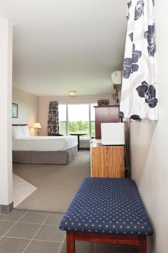 a hotel room with a bed and a blue bench at Brackley Beach Northwinds in Brackley Beach