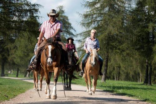 un grupo de personas montando caballos por un camino en Reiterhof Edelweiss, en San Genesio Atesino