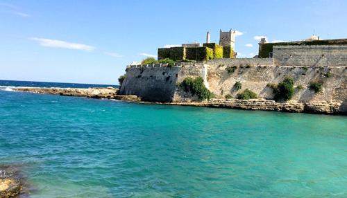 an island in the water with a castle in the background at Appartamento Antonacci in Monopoli