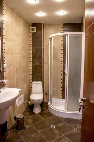 łazienka z prysznicem, toaletą i umywalką w obiekcie Apartment Elegant w mieście Welingrad