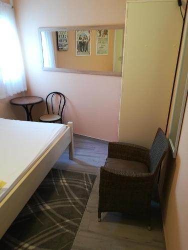 a room with a bed and a chair and a mirror at Cinema House Single & Double Rooms & Studio Apartments in Pula