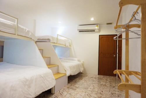a room with two bunk beds and a staircase at Boon Street Hostel in Bangkok
