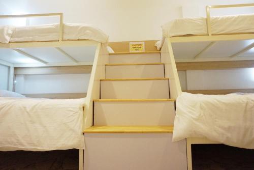 a bunk bed room with two bunk beds and shelves at Boon Street Hostel in Bangkok