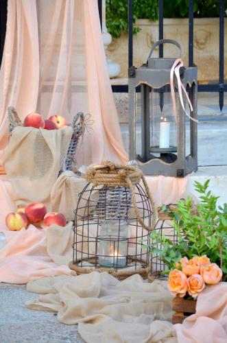a bird cage sitting on the ground with apples and candles at Archontiko Art Hotel in Galaxidhion
