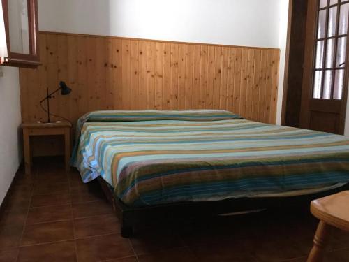 una camera con un letto e una parete in legno di Villetta Straccoligno a Capoliveri