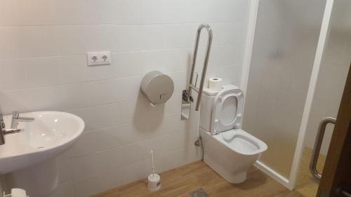 a bathroom with a toilet and a sink at Albergue Parroquial Santiago Apostol de Redondela in Redondela