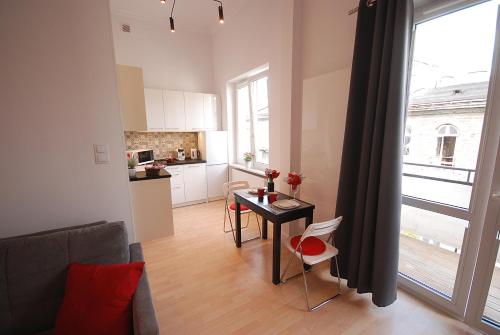 ein Wohnzimmer mit einem Tisch und einer Küche in der Unterkunft Nowy Apartament Wilcza in Warschau