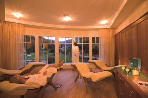 a woman standing in a living room looking out the window at Naturhotel MOLIN in San Giovanni in Val Aurina