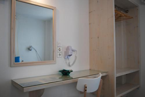 bagno con specchio e telefono appeso al muro di Aretousa Villas a Perissa