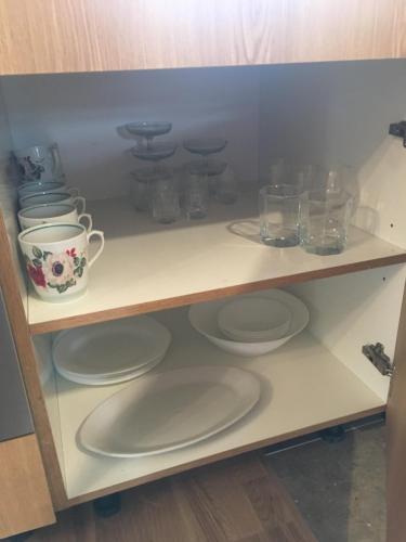 a shelf with plates and glasses on it at Ontic Wellness Apartments in Tartu