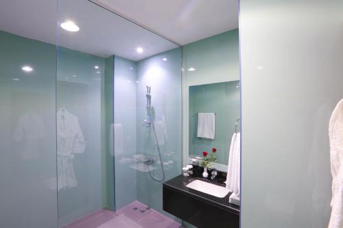 a bathroom with a glass shower and a sink at Ramada Encore Al Khobar Olaya in Al Khobar