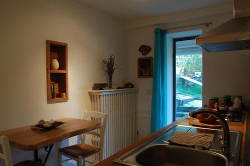 a kitchen with a sink and a table and a window at Radici House in Torgiano