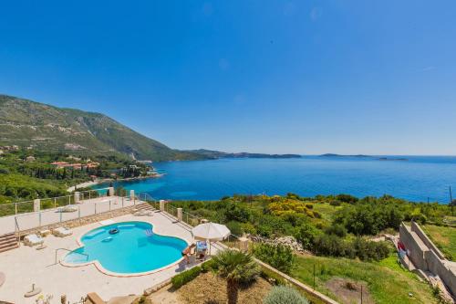 a villa with a swimming pool and a view of the ocean at Apartments Marnic in Mlini