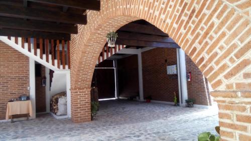 a brick hallway with an archway in a building at Hospedaje Herradura in San Miguel Regla