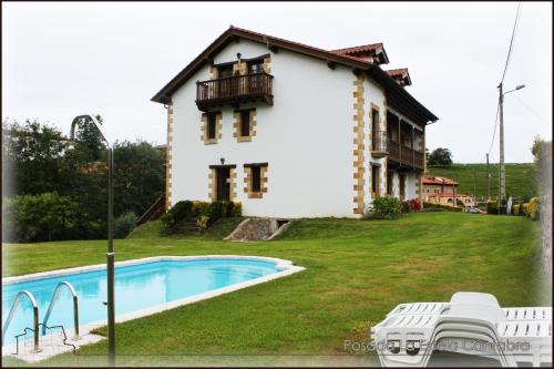 a house with a swimming pool in front of it at Posada La Estela Cántabra in Toñanes
