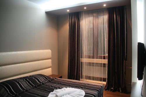 a bedroom with a bed and a window with curtains at Hotel Petrus in Paraćin