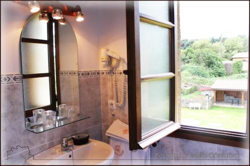 a bathroom with a sink and a mirror and a window at Posada La Estela Cántabra in Toñanes