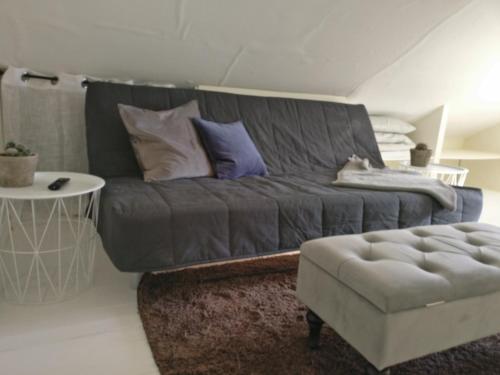 een woonkamer met een grijze bank en een kruk bij Lägenhet Färjestaden in Färjestaden