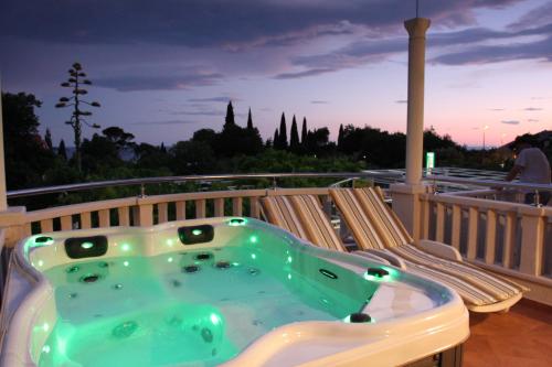a jacuzzi tub on the deck of a house at Apartments & Rooms Čakelić in Mlini