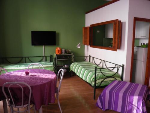 ミラノにあるグレッグスのベッド2台、テーブル、テレビが備わる客室です。