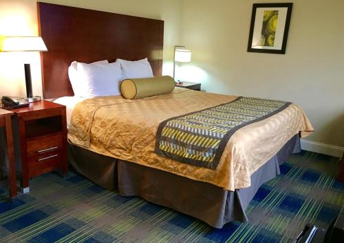 a hotel room with a bed, chair, and nightstand at Travelodge by Wyndham by Fisherman's Wharf in San Francisco