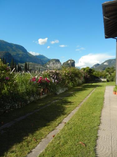 a path with flowers and the view of the castle at Al Fiume in Arco