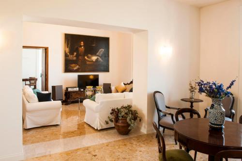 シラクーサにあるOrtigia Exclusive Apartmentのリビングルーム(白い家具、テーブル付)