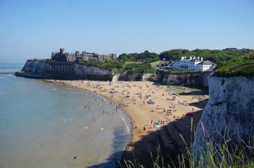 a group of people on a beach near the water at Broadstairs Beach Holiday Apartments, self-catering seafront stays at Kingsgate Bay, with parking space in Broadstairs