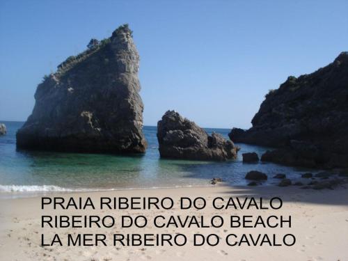 a beach with two large rocks in the water at Casa Teresinha in Sesimbra