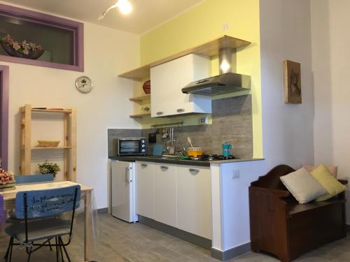 a kitchen with white cabinets and a table in a room at Casa di nonna Benedetta in Margherita di Savoia