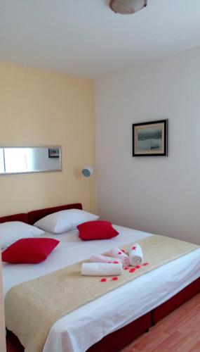 a bedroom with two beds with red and white pillows at Apartmani Biočić in Split