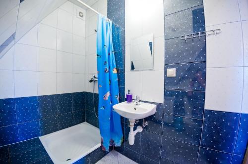 a blue and white bathroom with a sink and a shower at Dom Wypoczynkowy Słoneczny in Białka Tatrzańska